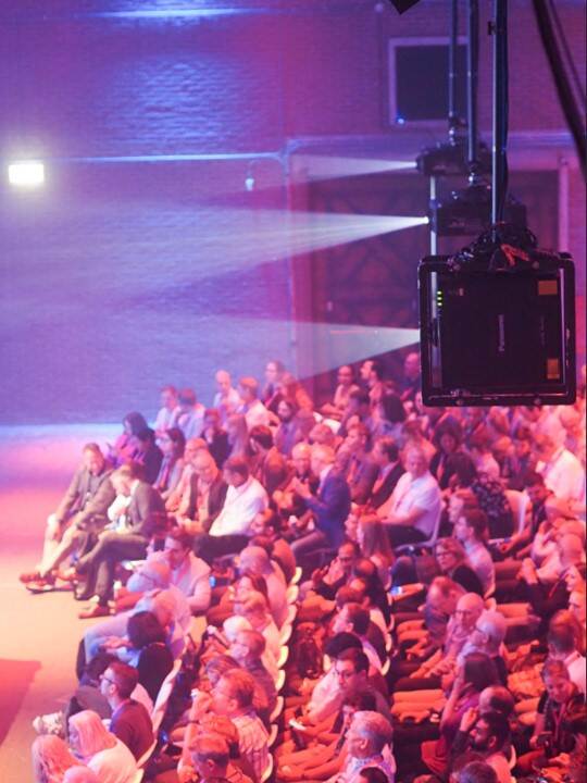 Een volle zaal collega's in de plenaire ruimte van De Fabrique.