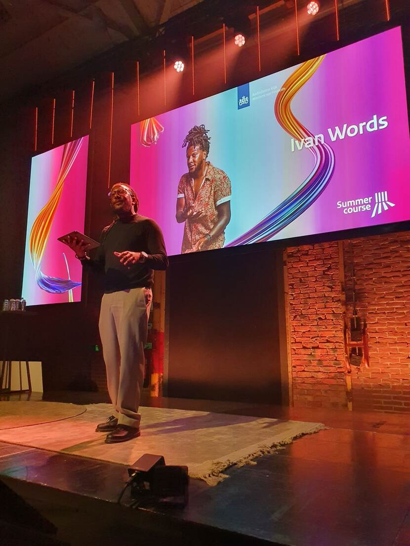 Woordkunstenaar Ivan Words vatte de dag scherp samen op het podium van de plenaire zaal.